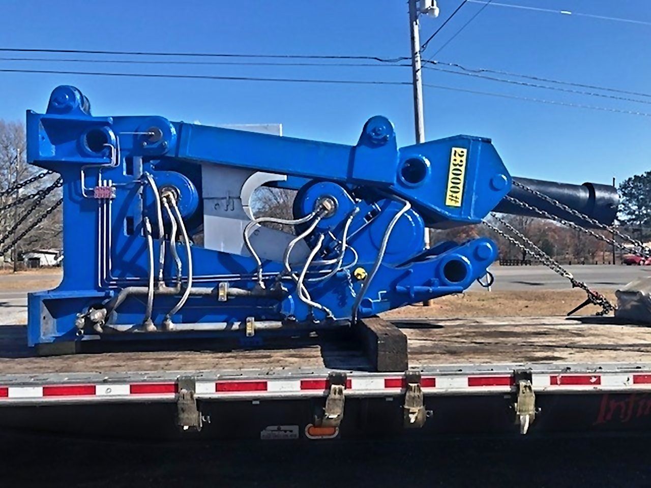 Blue 23,000 lb assembly, tagged 23000#, chained down on a flatbed trailer for shipping